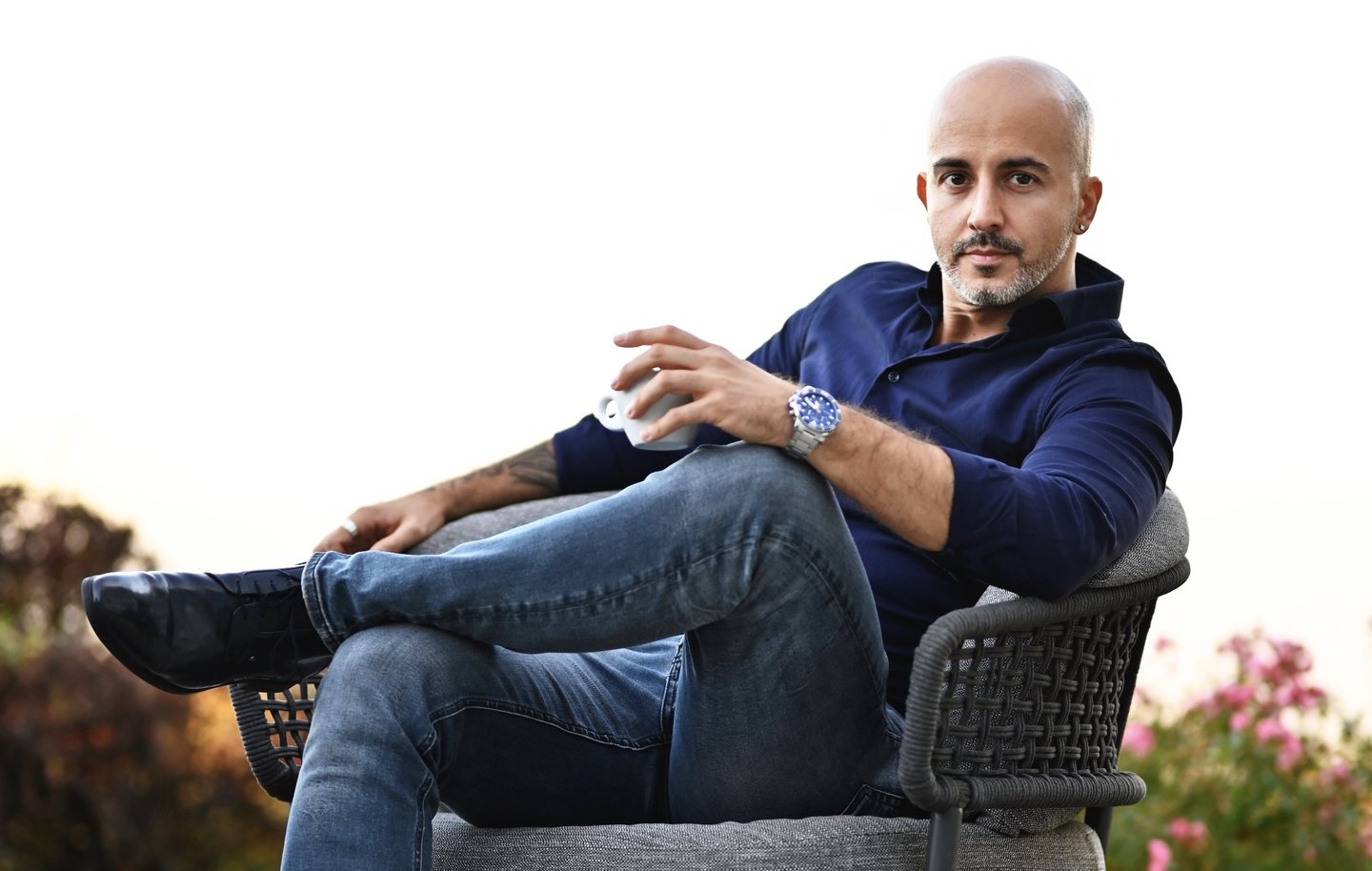 Rob Toth seated in a garden chair with a coffee, looking at the camera